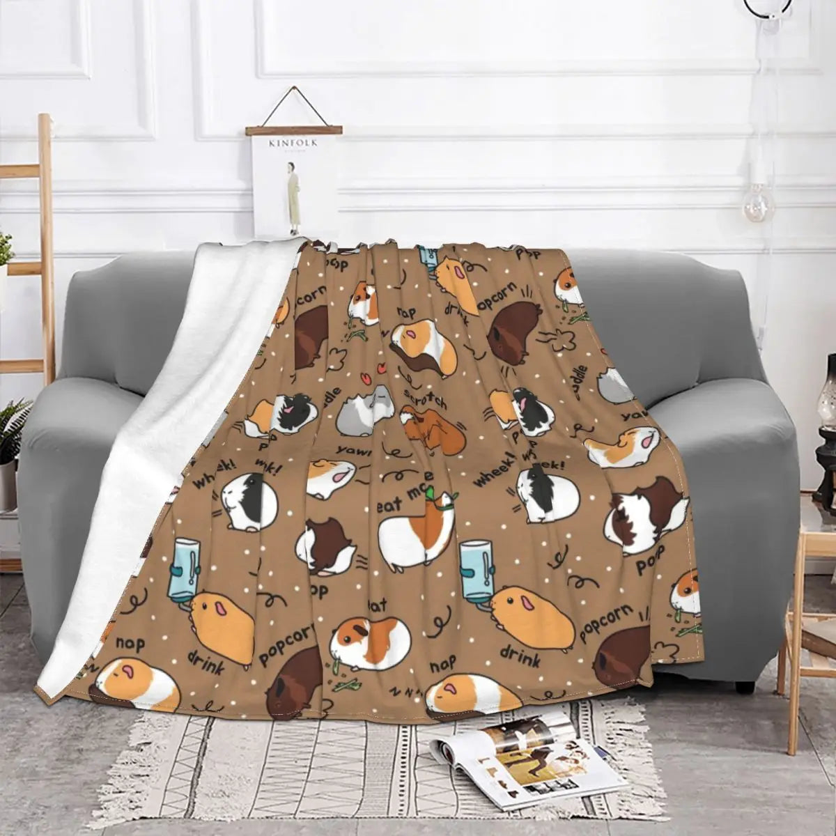 Brown guinea pig throw blanket with cartoon guinea pigs and words pattern, on sofa