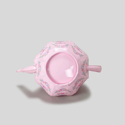 Pink teapot-shaped mini bag with circular front opening and floral print