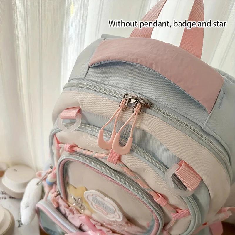 Pastel backpack front with layered zipper pockets and dangling ribbon accents