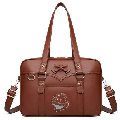 Brown faux-leather messenger bag with bow emblem, star accents, and crossbody strap