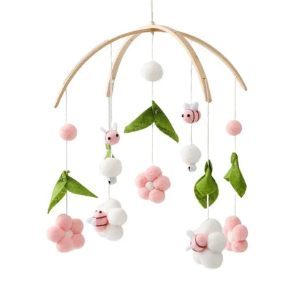 Wooden baby crib mobile with leaf, bee, and pink flower hanging charms