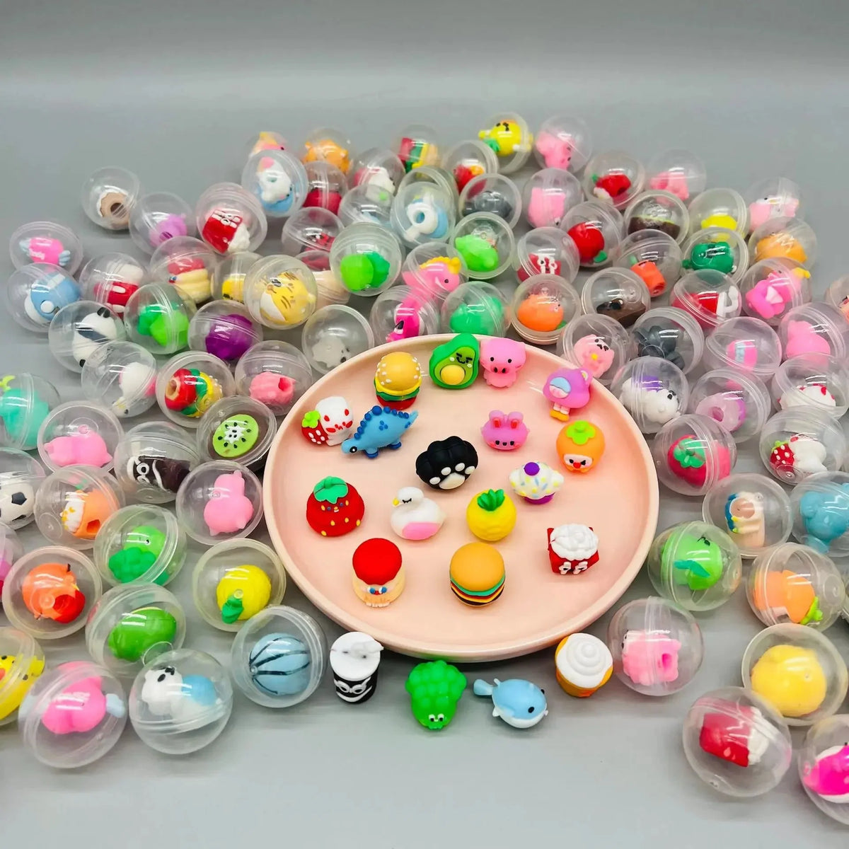 Transparent capsule eggs around a round tray of small colorful toy charms