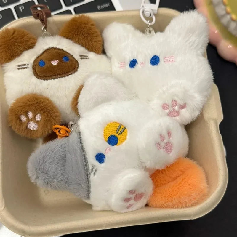 Brown and white cat plush keychains with blue eye faces and metal key rings