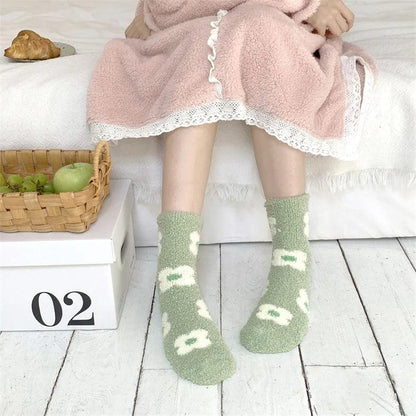 Plush sleeping socks on legs, sage green with small white motif details