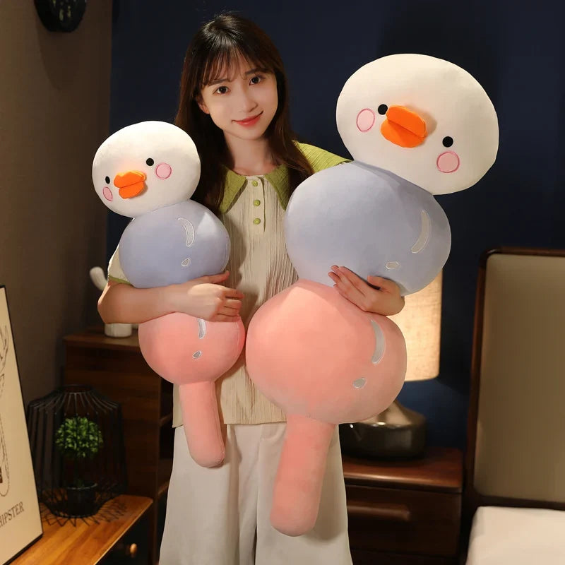 Pair of duck dango snack plush toys with orange beaks, held by a person