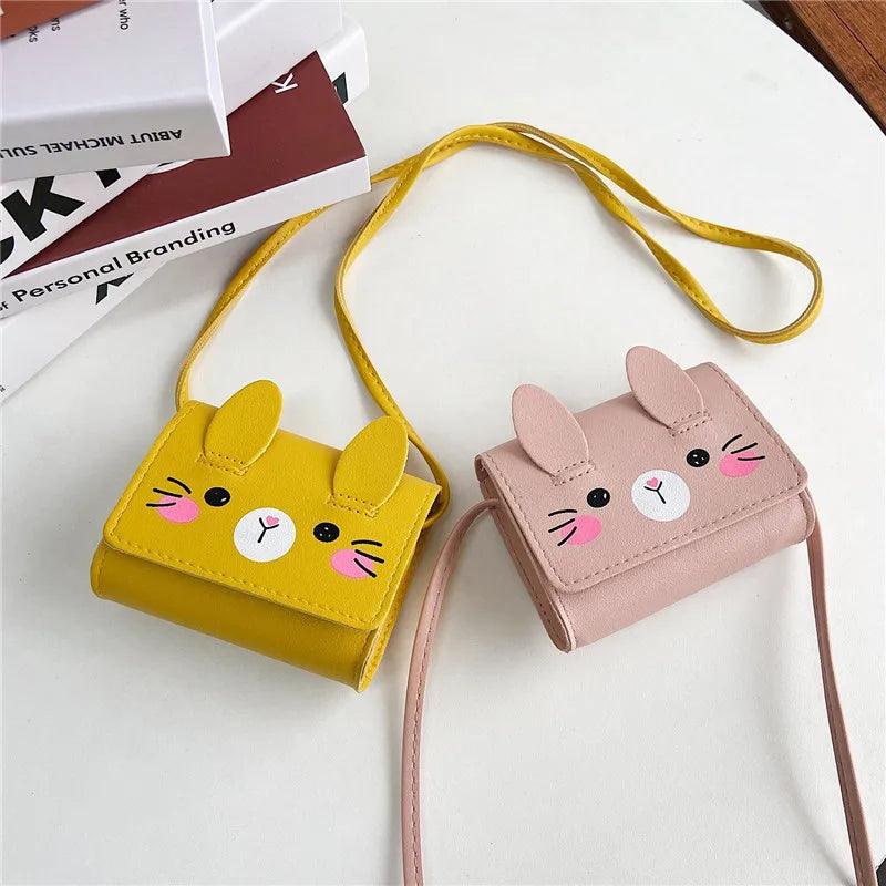 Yellow and blush pink bunny crossbody bags with stitched faces and adjustable strap