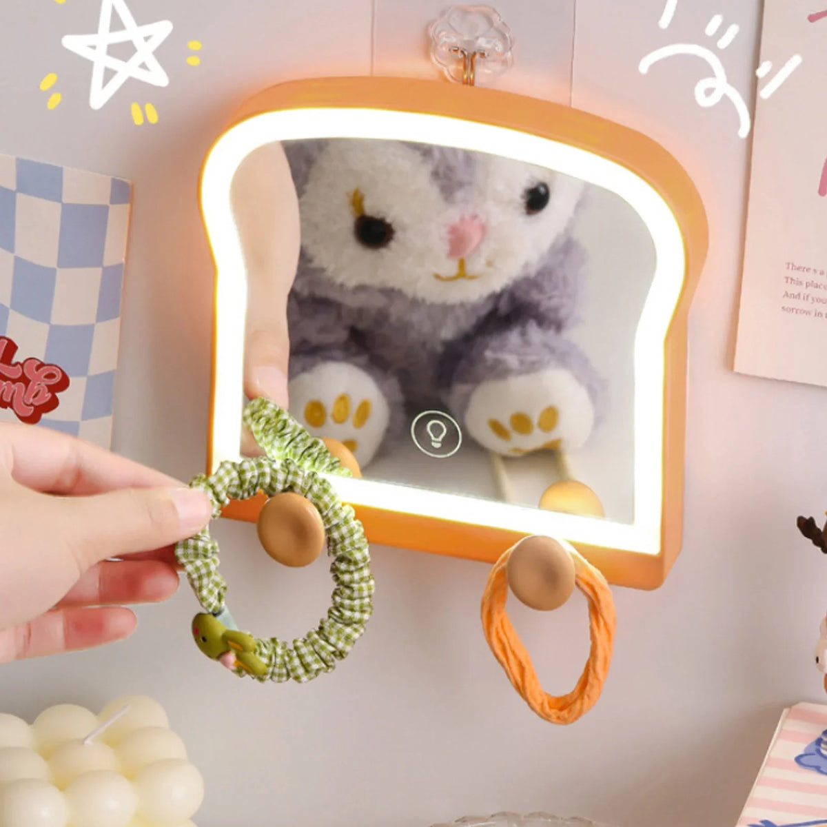 Toast-shaped LED makeup mirror with gray plush cat graphic, warm glow and hanging hair ties