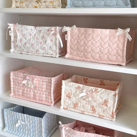 Decorative fabric storage boxes on shelf, pink and white patterns with ribbon bows