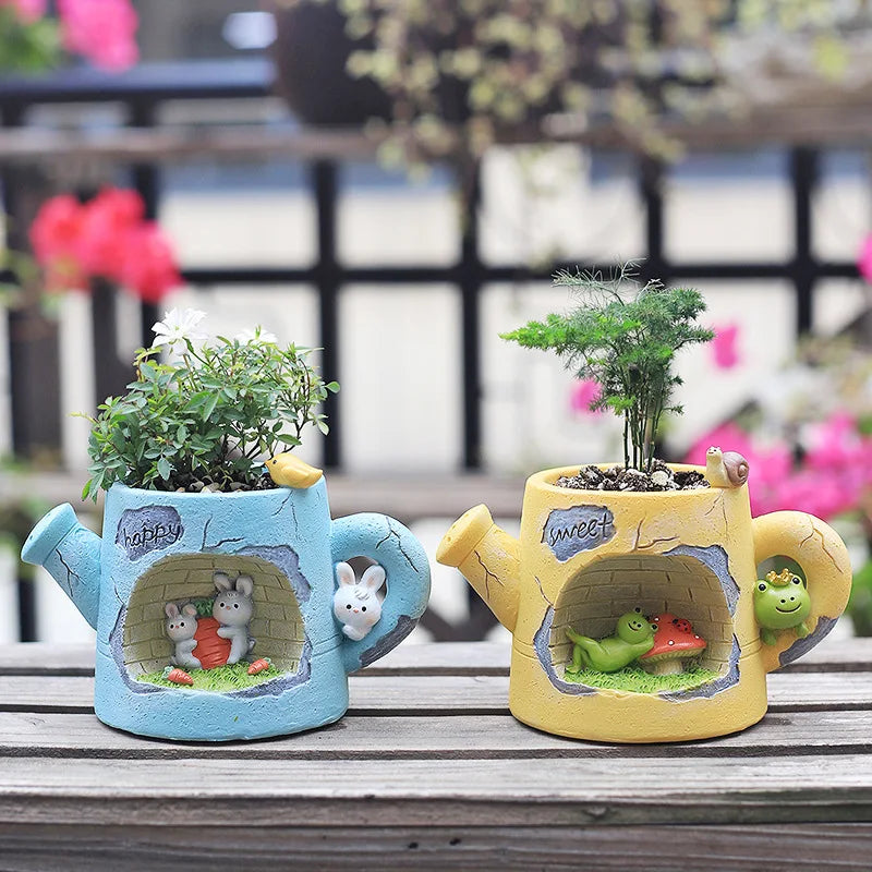 Resin watering can plant holders on a bench with green saplings and bunny/frog faces