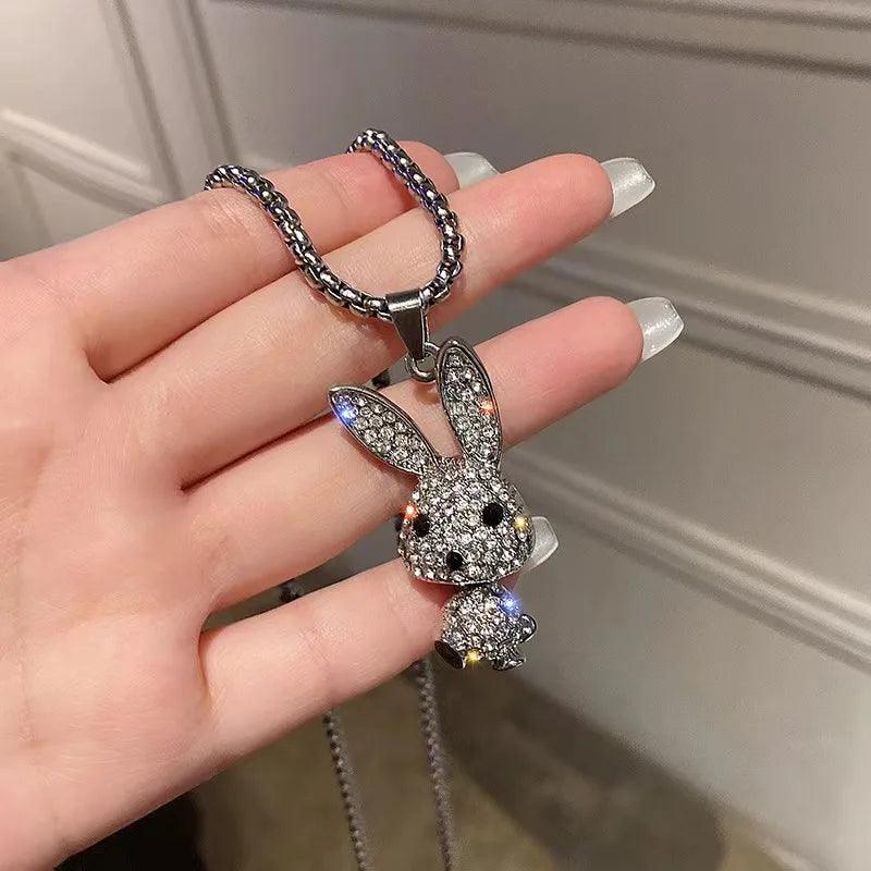 Rhinestone rabbit pendant necklace held in a hand, showing ear and face details