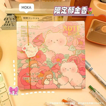 Pink illustrated notebook cover with two rabbits, flowers, and 'LILY OF THE VALLEY'