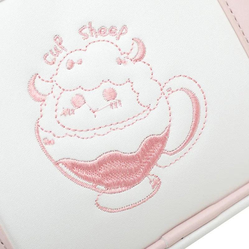Kawaii messenger bag with white body and pink stitched cat cupcake applique on front