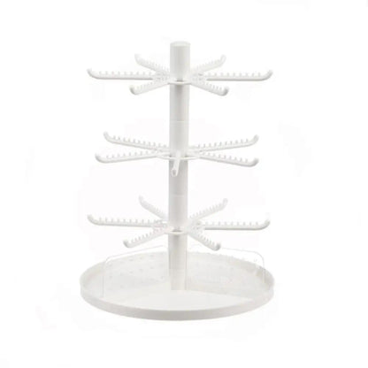 White rotating earring display stand with three tiers of hook arms and clear base