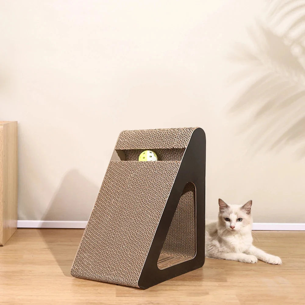Triangular cardboard cat scratcher with toy ball; white cat resting beside the base