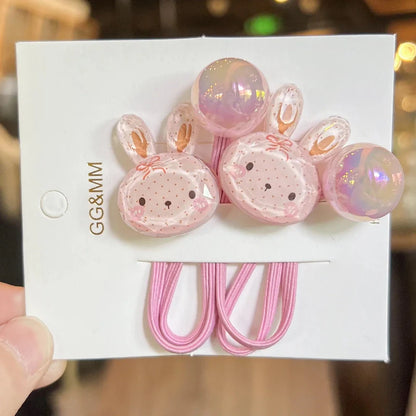 Pink elastic hair ties with bunny and heart charms with pearly bead details on card