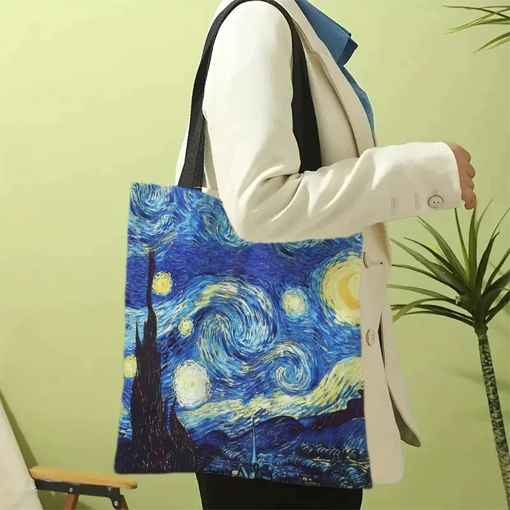 Blue canvas tote bag with Starry Night print and black shoulder handles