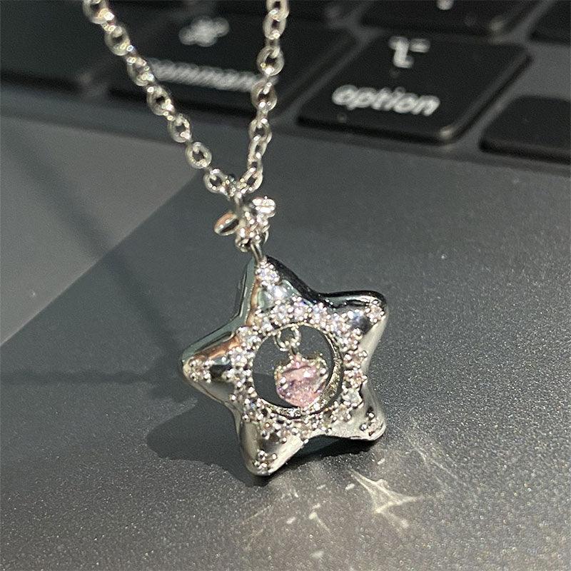 Silver star necklace pendant with pink center gem and sparkling pave detail on chain