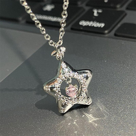 Silver star necklace pendant with pink center gem and sparkling pave detail on chain