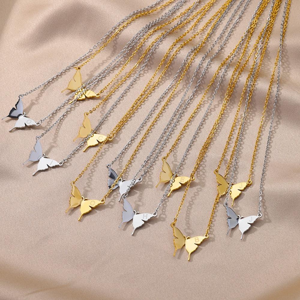Assorted butterfly pendant initial necklaces on chain in gold and silver tones