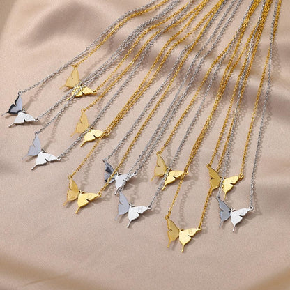 Assorted butterfly pendant initial necklaces on chain in gold and silver tones