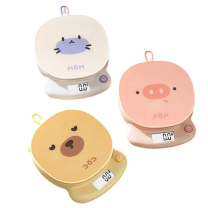 Digital kitchen scales showing cat, pig, and bear faces with round tops