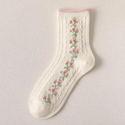 White socks with embroidered floral vines in pink, green, and red