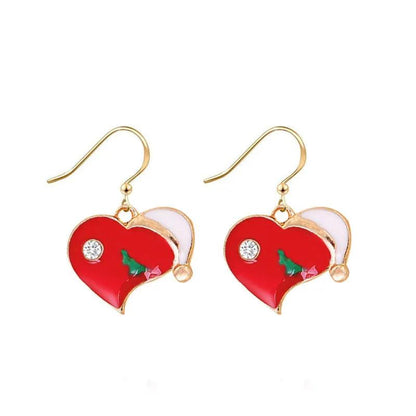 Red heart drop earrings with gold hooks, white crystal detail, and green Christmas tree charm