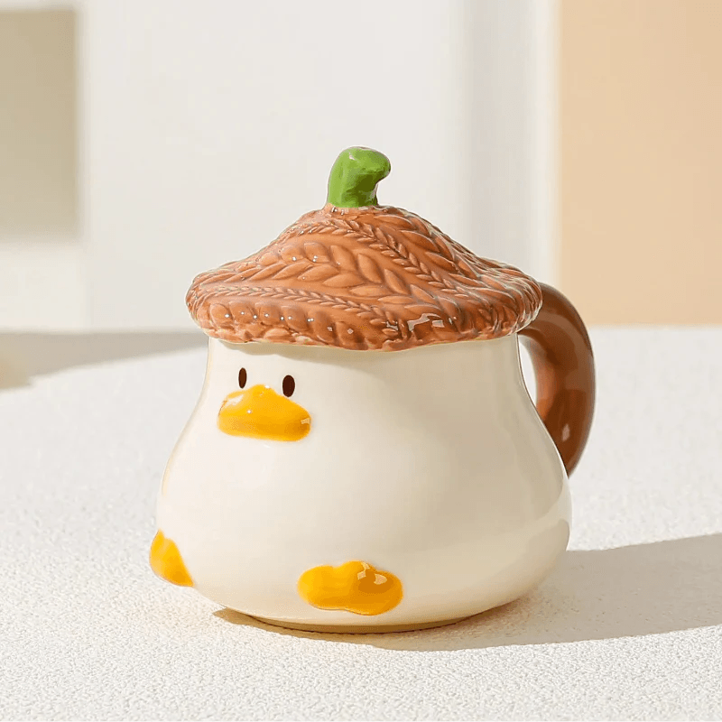 Duck-shaped ceramic mug with brown textured lid, orange beak face, and side handle