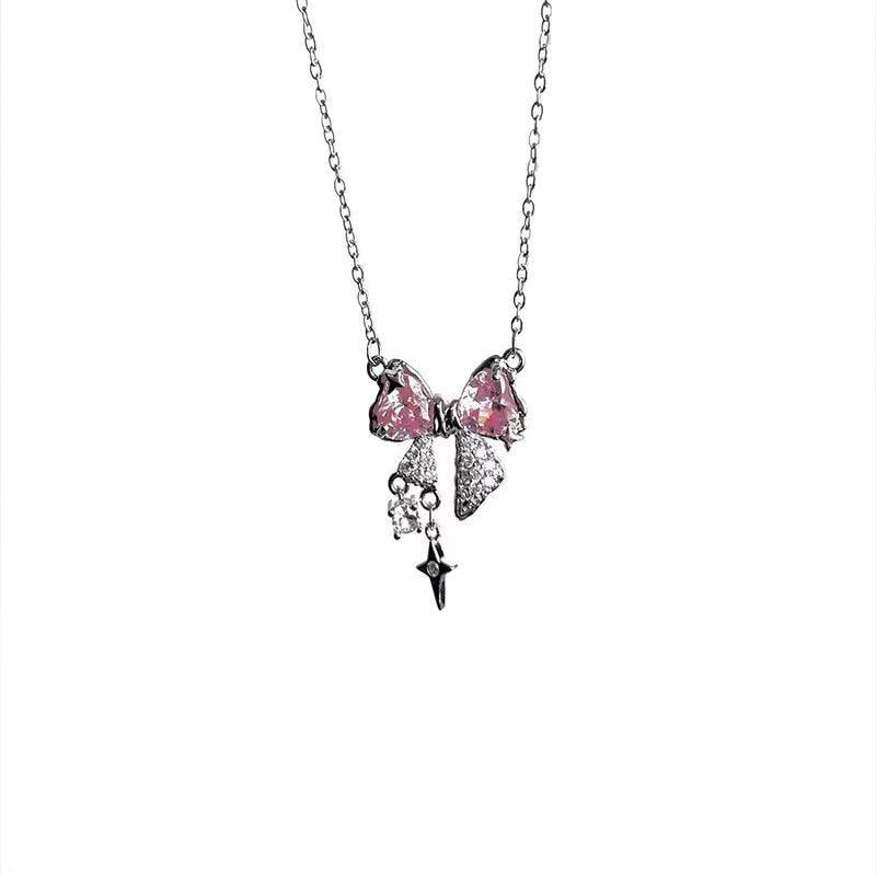 Bow pendant necklace with pink crystal bows, star drop charm, and silver chain