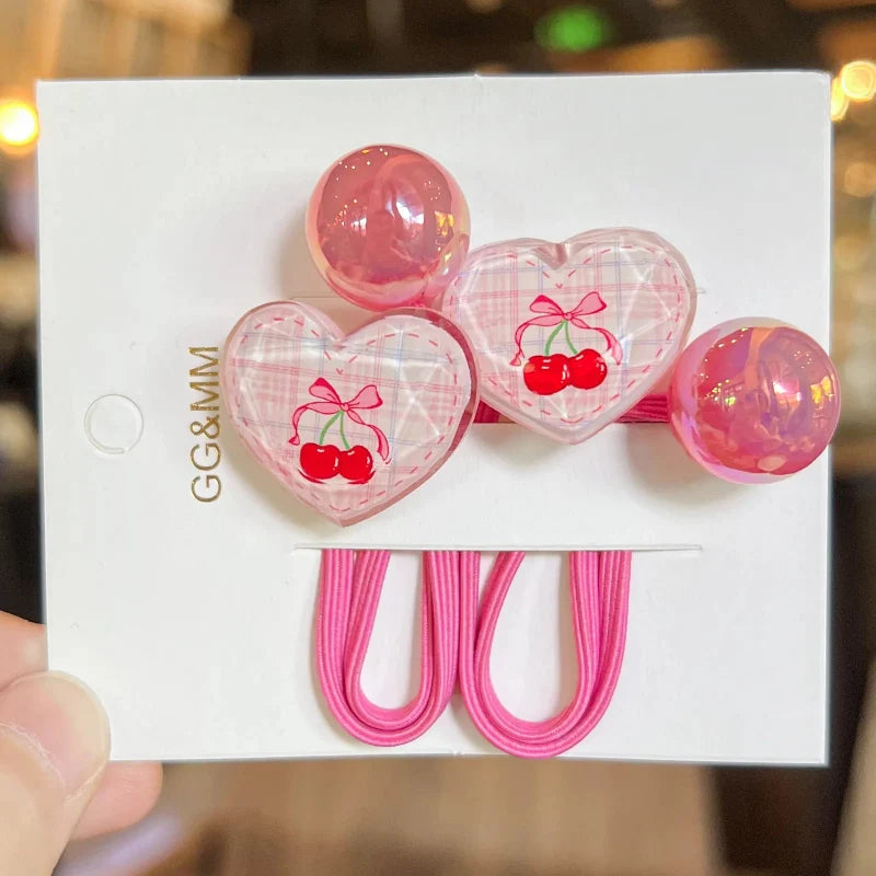 Pink elastic hair ties with heart charms and cherry bunny graphics on card backing