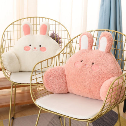 Plush bunny cushions: white bunny and pink bunny with long ears on chairs.