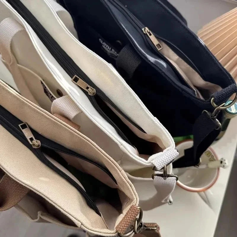 Beige canvas tote bag interior view with multiple zip compartments and inner pockets