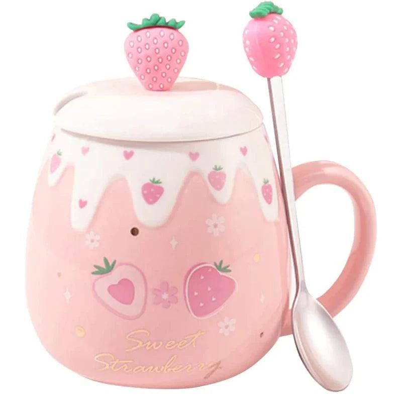 Pink ceramic mug with white lid and strawberry topper, spoon at side; strawberry heart print