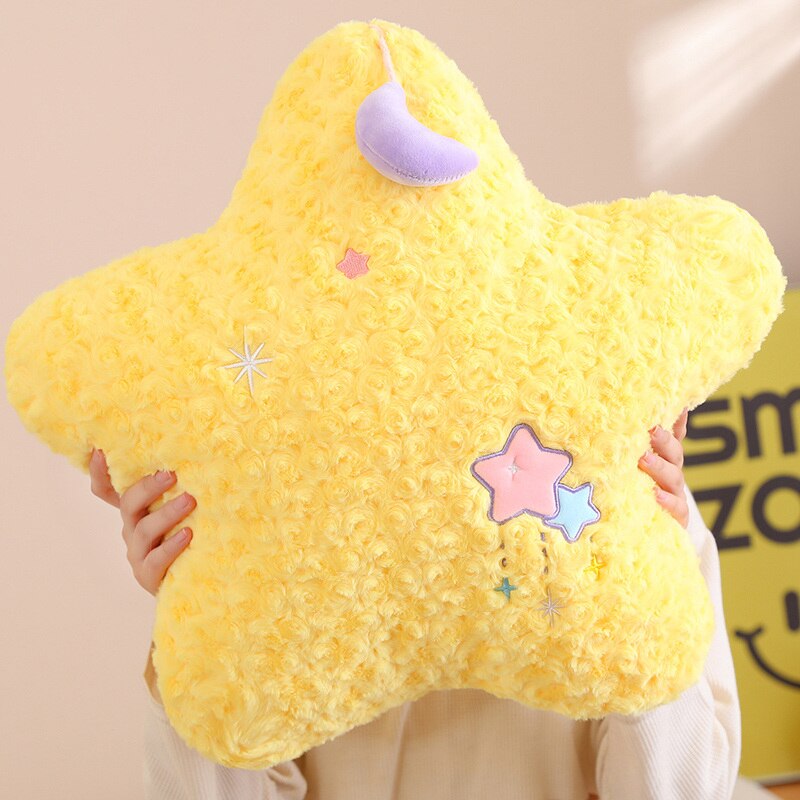 Yellow plush star pillow with purple crescent moon and star patches, soft curly texture