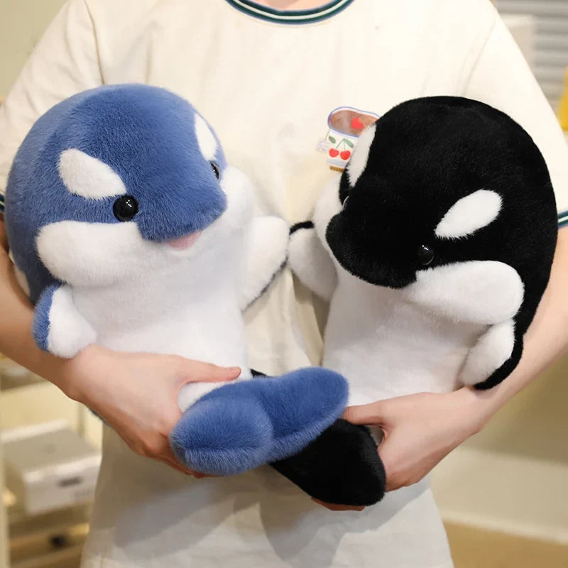 Blue and white dolphin plush toy with black eyes and curved body design.