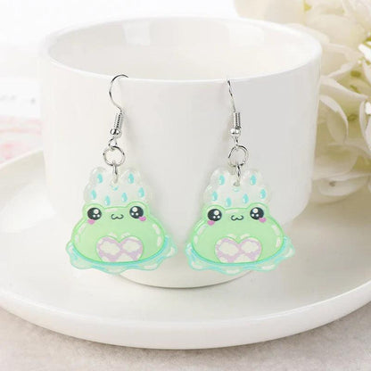 Frog acrylic earrings with light green frog charms, purple eye details, heart center, and silver hooks