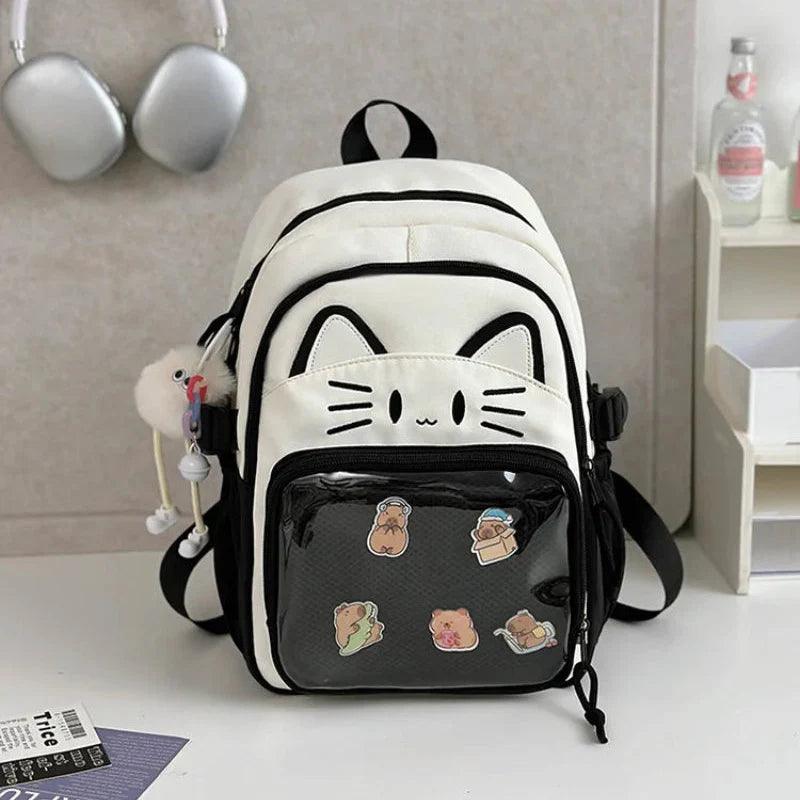 White cat school backpack with black trim; clear front pouch with cartoon food patches.
