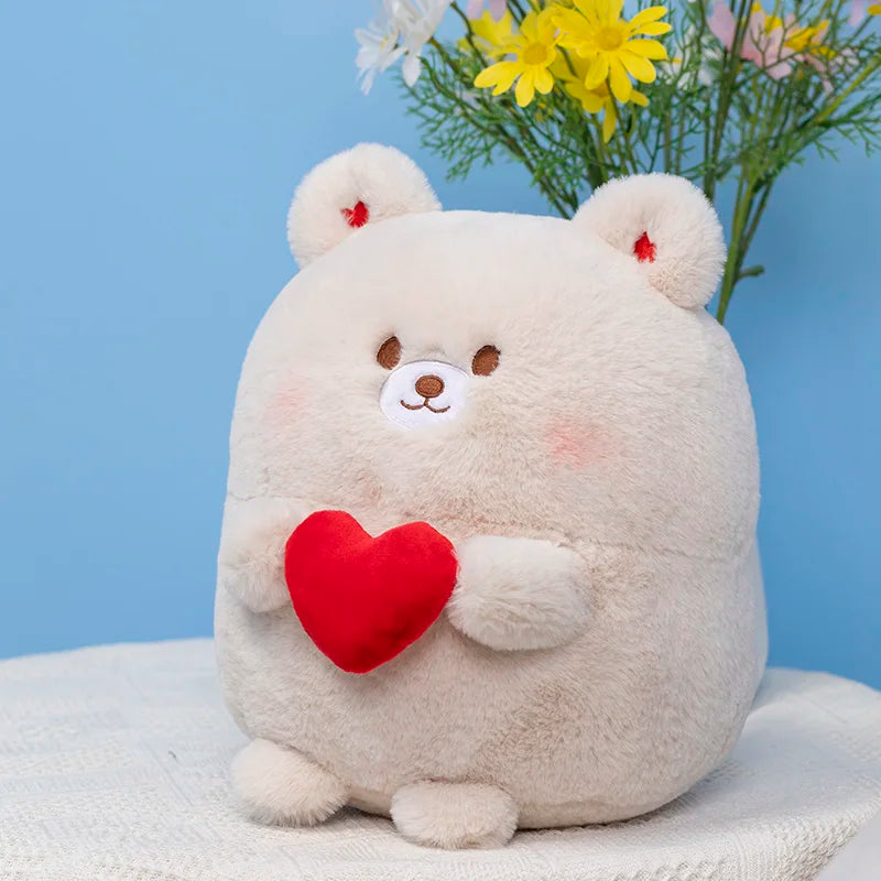 Cream bear plush with red heart on its chest, sitting against a blue backdrop.