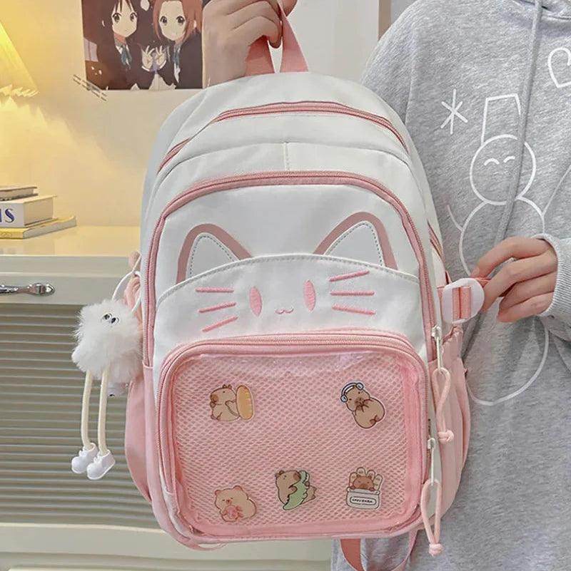 Pink and white cat-face school backpack with mesh front pocket and stitched cartoon patches