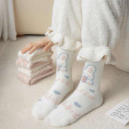 Bunny socks on feet with white fuzzy texture and pastel bunny paw designs on the cuffs.