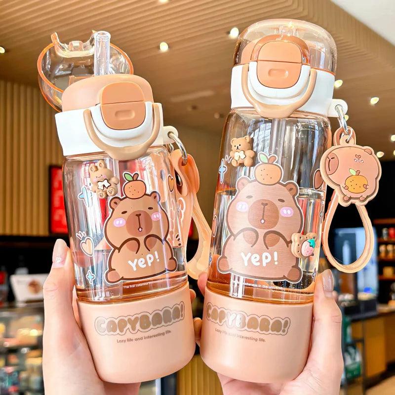 Two capybara-themed water bottles with clear bodies, white caps and orange latches, cartoon designs