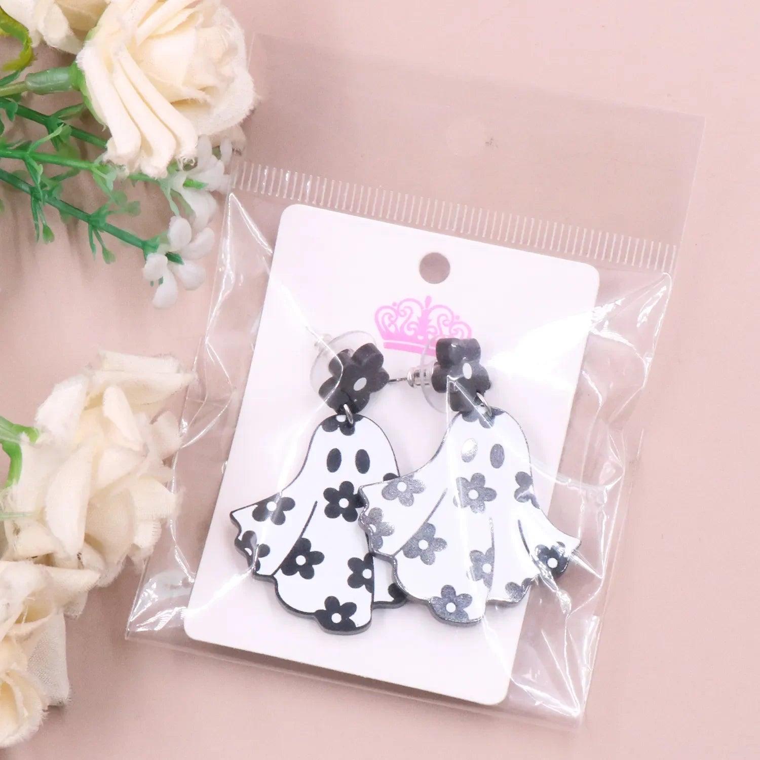 Ghost earrings in clear package, black flower tops with white floral ghost charms