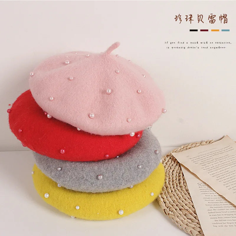 Stack of felt berets in pink, red, gray, and yellow with faux pearl dots