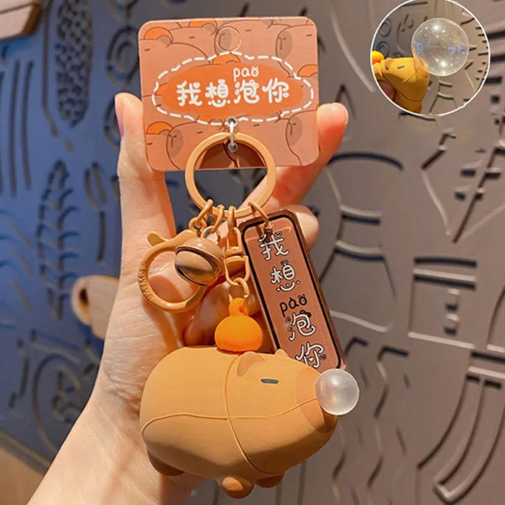 Capybara keychain with hanging tag, clear bubble dome and squeeze toy body