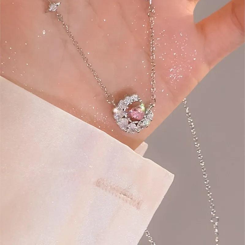 Heart zircon pendant with pink center stone on a thin silver chain, worn near neckline