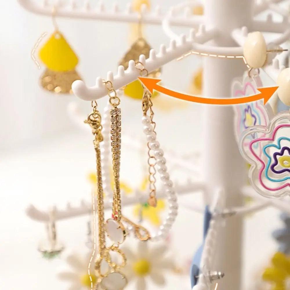 Earring display stand close-up showing white hook arms and hanging earrings
