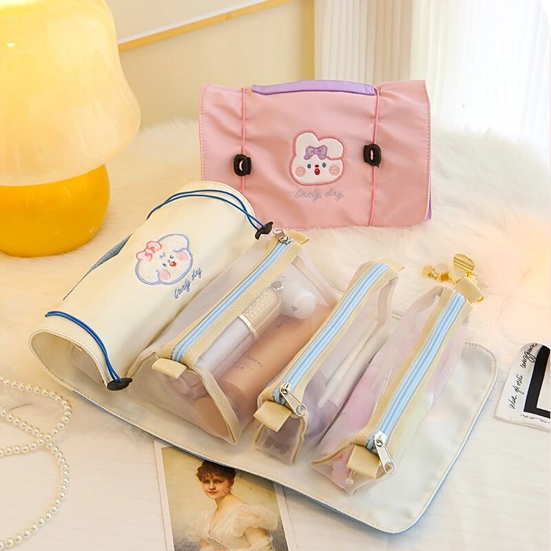 Rolled pink and beige roll-up makeup bag with multiple clear zip pockets inside