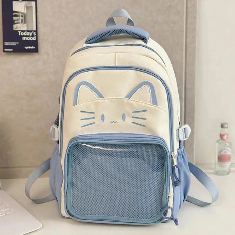 White cat school backpack with blue trim; front mesh pocket and side zipper charms.