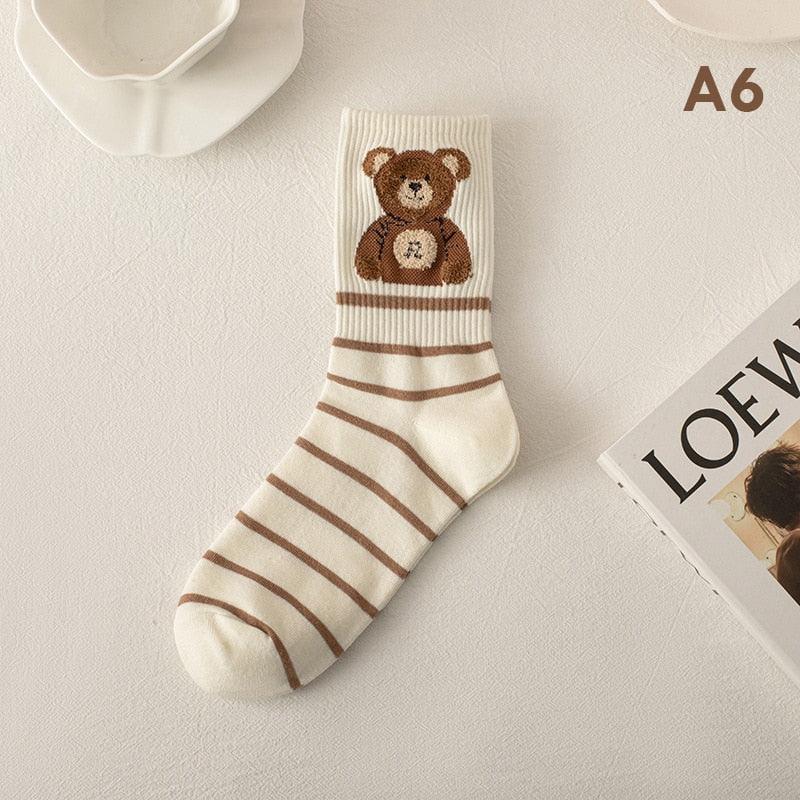 Cream socks with brown teddy bear graphic and horizontal striped pattern