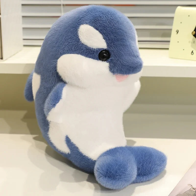 Blue dolphin plush with white belly and fin, embroidered eye and smiling muzzle